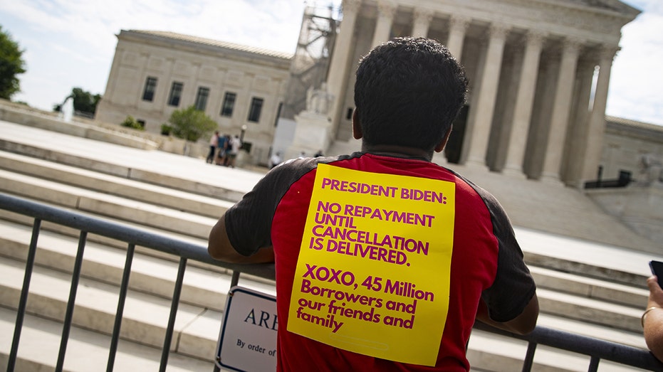 A protester waits outside the U.S. Supreme Court building for its decision on President Biden's student loan forgiveness program