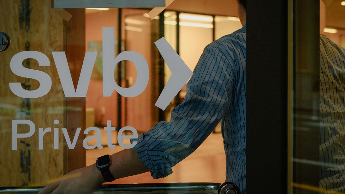 An employee holds the door open at the Silicon Valley Bank branch office in downtown San Francisco, California, on March 13, 2023.