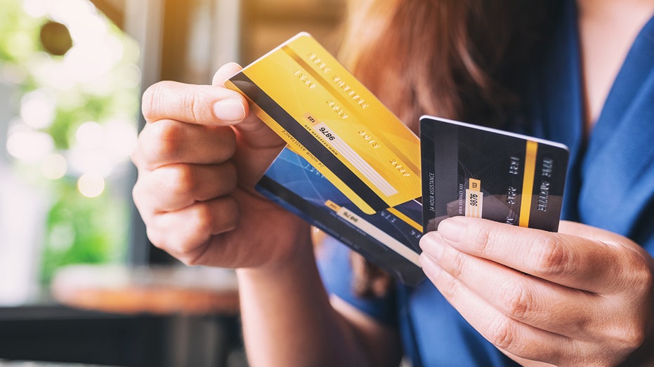 A woman holds credit cards.