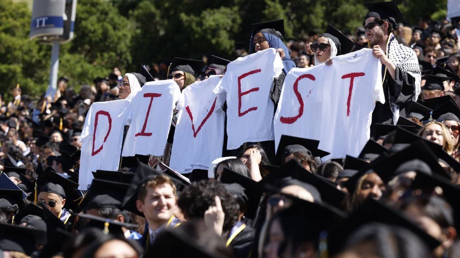 Students holding DIVEST shirts