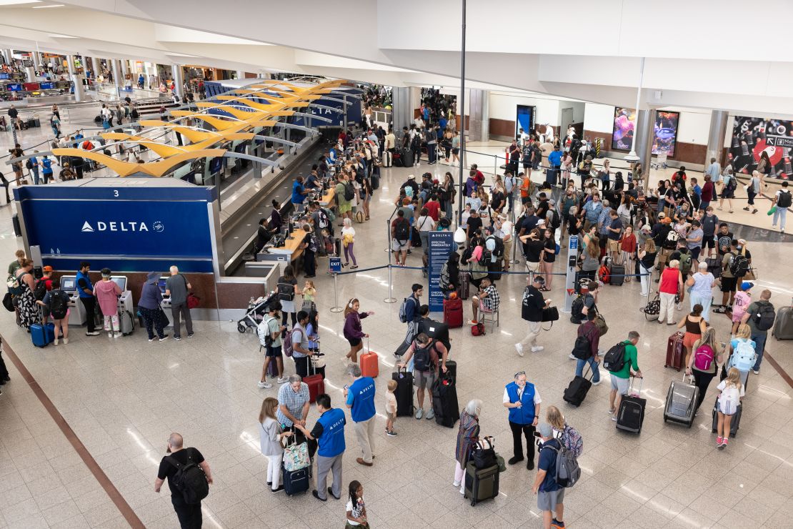 Delta Air Lines passengers line up for agent assistance Monday at Hartsfield International Airport in Atlanta on Monday.