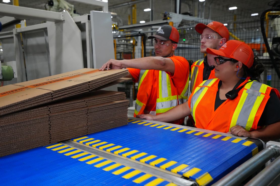 Interpreter Elissa Ramirez, right, helps supervisor Stacey Thomas, center, train machine operator Eduardo Vera at DS Smith's packaging facility in Lebanon, Indiana.