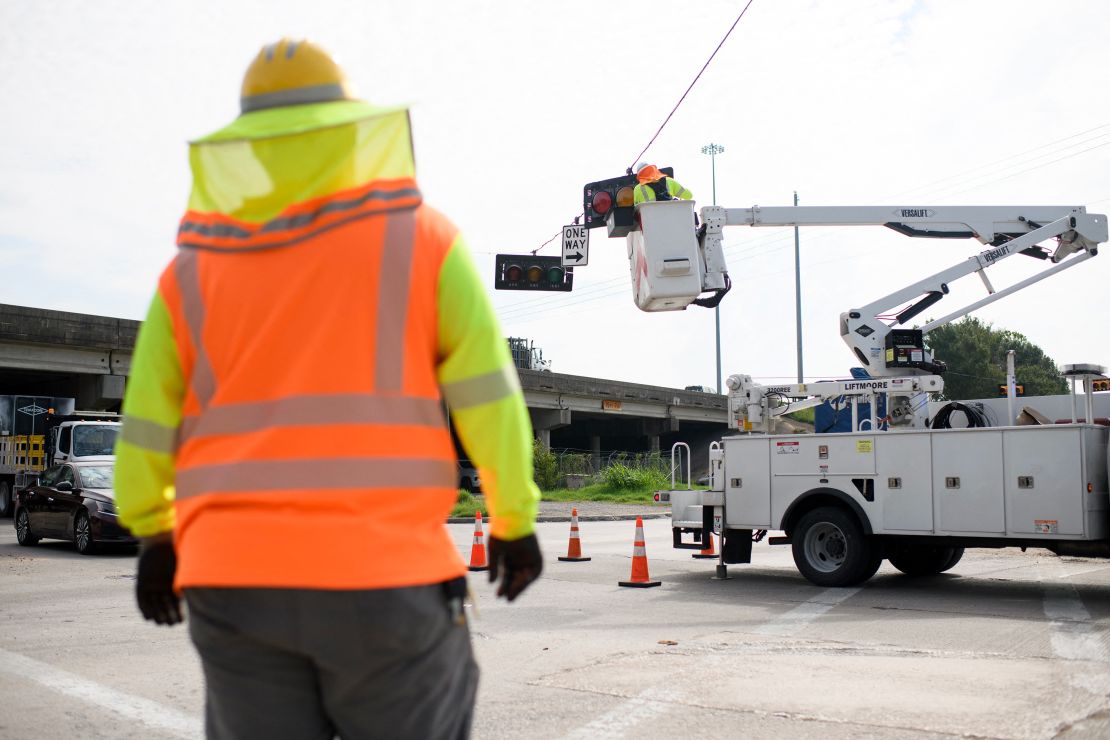 A linesman repairs a stoplight in Houston, Texas on July 11, 2024. Millions of people in Texas are still grappling with power outages and facing the looming dangers of intense heat and humidity following Hurricane Beryl.