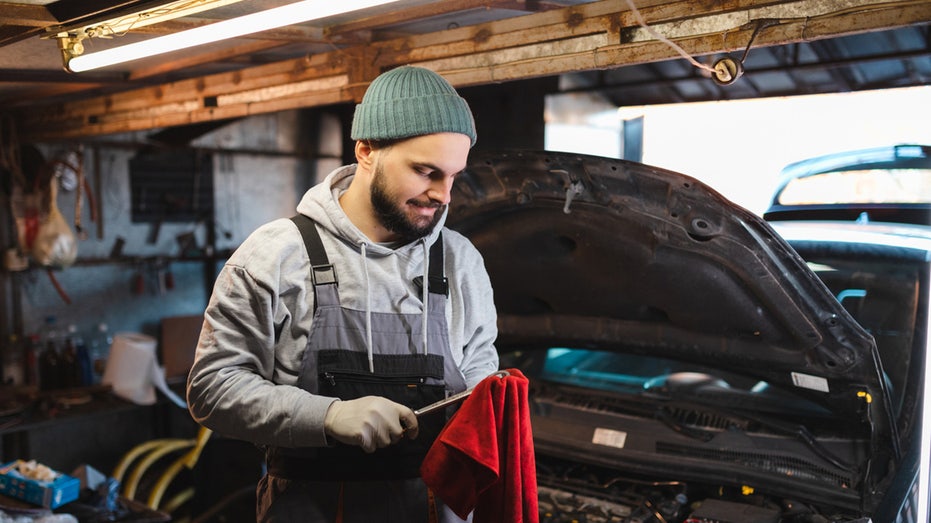 young mechanic with wrench in garage